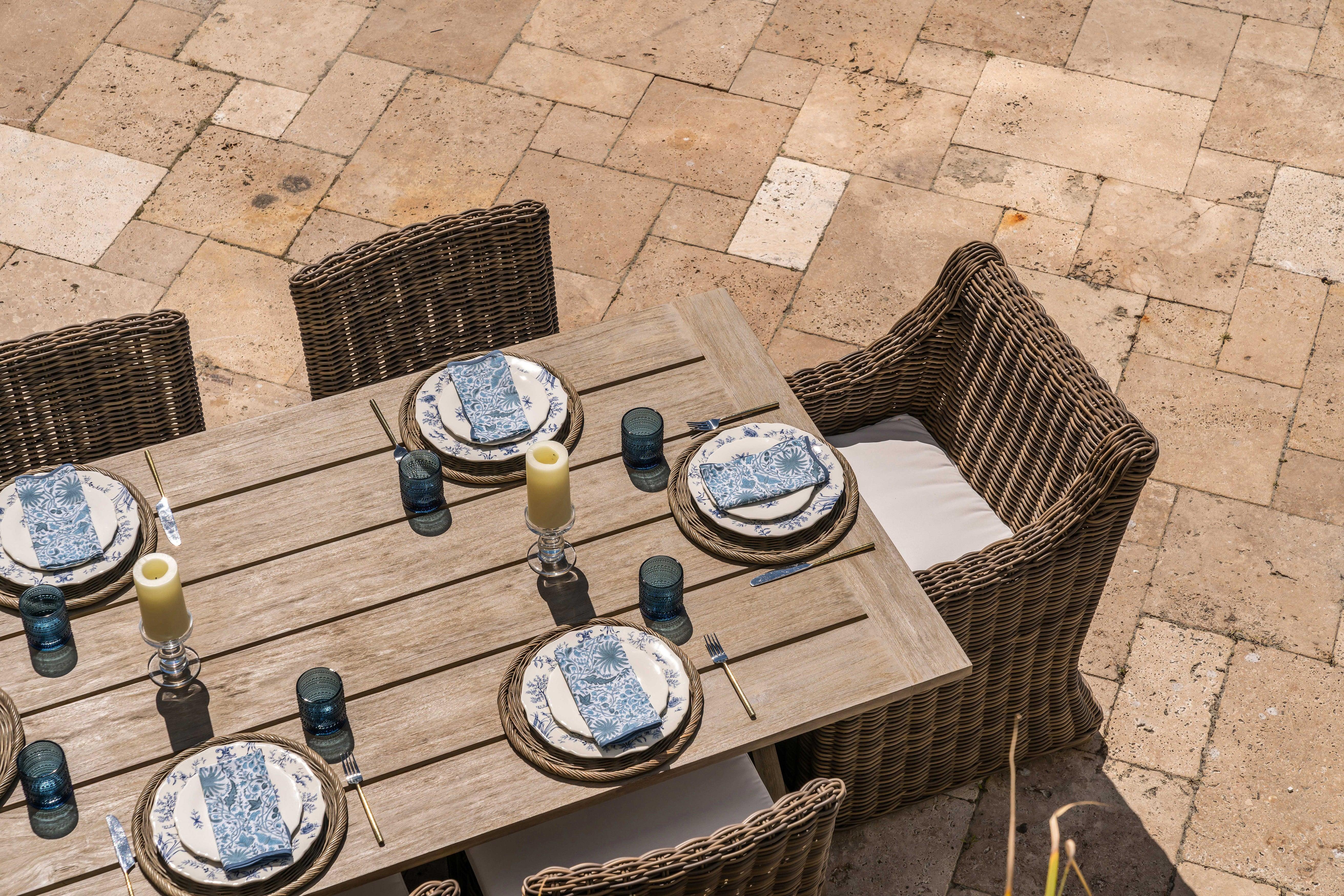 Grey teak wood dining table with wicker patio dining chairs